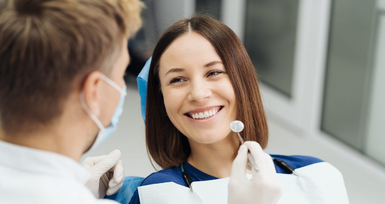 Male Professional Dentist With Gloves And Mask And Discuss What The Treatment Will Look Like Of The Patient's Teeth. Discussion Of The Treatment Plan And Healthy Smile